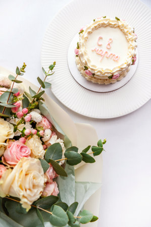Festive bento cake and bouquet on a light backgroundの写真素材