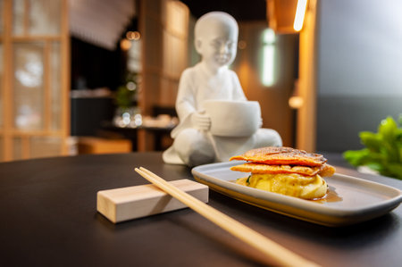 Sea bass fillet on a bed of mashed potatoes and spinach close-up on a gray plateの写真素材