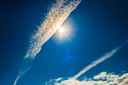 Strong sun and skies and clouds with lens flareの写真素材