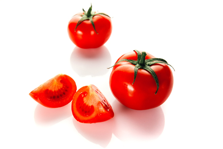 Red ripe tomato with the handle isolated on white backgroundの写真素材