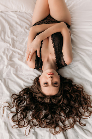 Sexy brunette in bed in underwearの写真素材