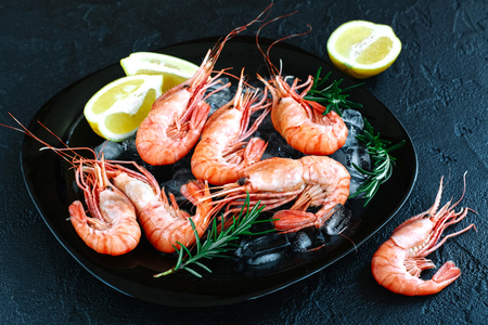 Tiger shrimps with lemon, rosemary on stone background.の写真素材