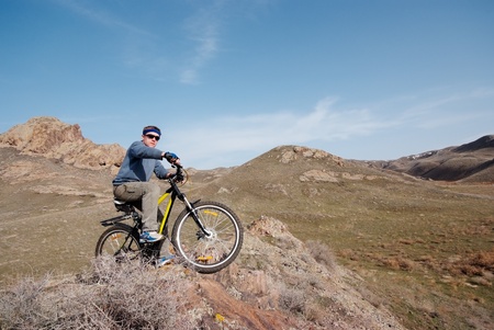 Bicyclist in mountain terrain overcomes obstacleの写真素材
