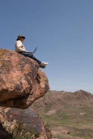 Man with the laptop sits on the brink of breakage  Vertical frameの写真素材