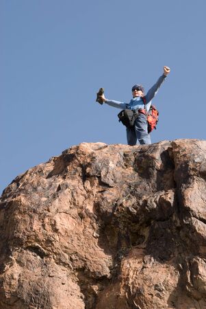 Climber exults on top standing upの写真素材