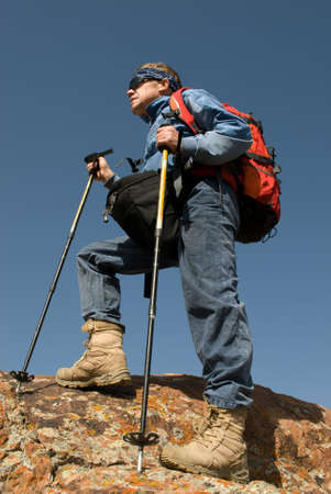 Tourist with a backpack on a rock looks afarの写真素材