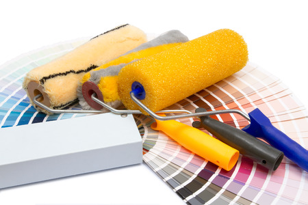 three painting rollers and album of colors on a white backgroundの写真素材
