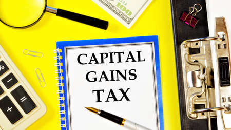 Capital gains tax-text label in the form of a document Registrar planning folder. Mandatory gratuitous payment is established by law by the state government.の写真素材