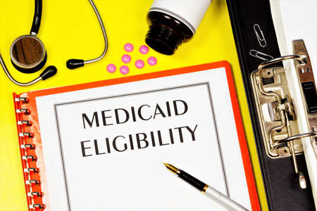 Eligibility for Medicaid - text inscription on the form on the medical folder. A Federal-state health insurance program designed for low-income residents.の写真素材