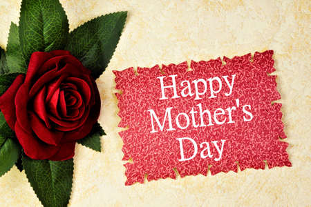 Greeting card with written text-happy mothers' day. Creative red rose flower gift and holiday background decoration.の写真素材