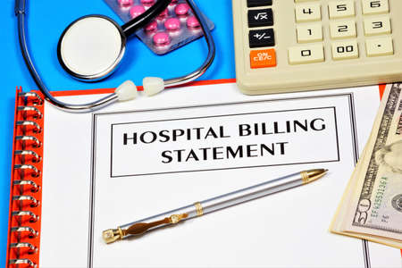 Hospital account statement. Text label in the form on the folder. Statement of a financial institution, against the background of medical supplies, stethoscope, pills.の写真素材