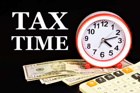 Tax time -Text inscription on the background of cash notes and planning reminders. Fee in cash. Bill payment.の写真素材