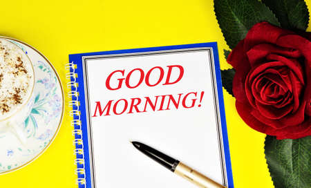 Good morning. Text inscription in a Notepad on the background of an invigorating drink and a red rose of joyful mood.の写真素材