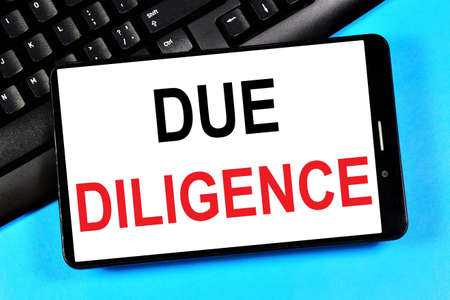 Due diligence. Text message on the smartphone screen. Great effort and diligence in planning the strategy of business tasks.の写真素材