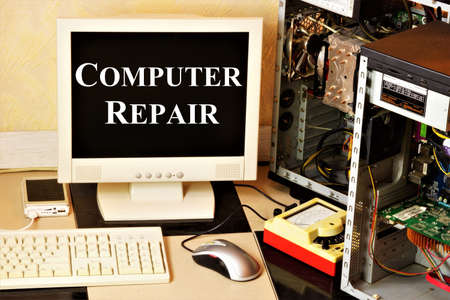 Computer repair. Text label on the monitor screen. Background of PC system blocks, mouse, keyboard. Maintenance of electronic equipment, for stable operation.の写真素材