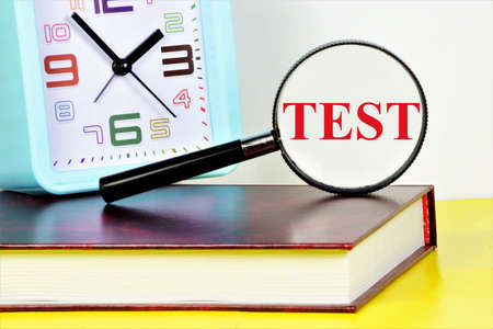 Test. Text inscription on the background of the clock and the textbook. The method of analysis of knowledge measurement, expert processing and evaluation of results.の写真素材