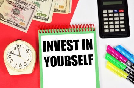 Invest in yourself. The inscription in the notebook on the background of the clock. Placement of capital for the purpose of obtaining financial profit or knowledge in education.の写真素材
