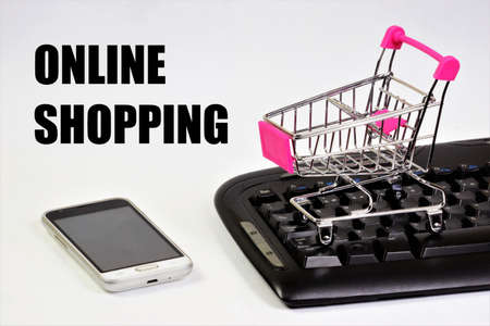 Online shopping on the Internet at favorable prices. An inscription on the background of a shopping basket, a smartphone and a computer keyboard.の写真素材