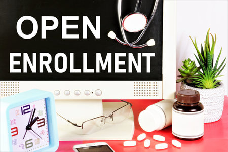 Open enrollment. The inscription on the monitor screen against the background of medicines and a stethoscope. Scheduling an appointment at a medical facility.の写真素材