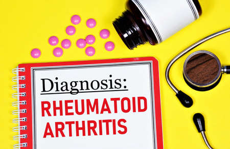 Rheumatoid arthritis. The inscription of the diagnosis in the medical folder, against the background of a stethoscope and medicines.の写真素材