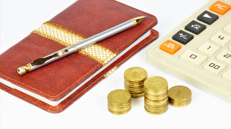 Coins and a calculator. Notepad and pen for planning and maintaining financial statements.