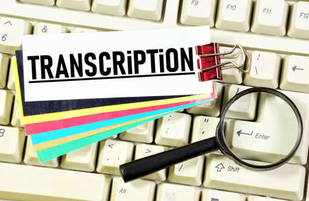 Transcription. The inscription on the background of the keyboard and magnifier. Presentation of oral speech in writing.の写真素材