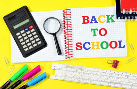 back to school. The inscription in the student's notebook on the background of a calculator, a magnifying glass for research, colored markers and a ruler. An opportunity to gain new knowledge.の写真素材