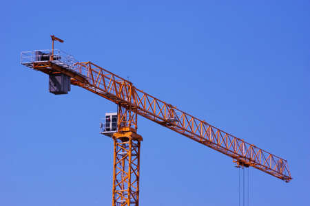 Tower construction crane, lifting mechanism with a rotary boom, against the sky.の写真素材