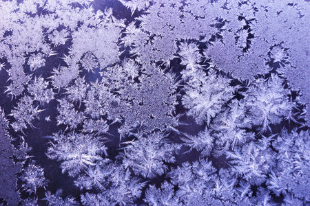 Frost on the glass. Abstract background of frozen water vapor on glass, forms a natural unique pattern applicable to design, creativity and the winter holiday.の写真素材