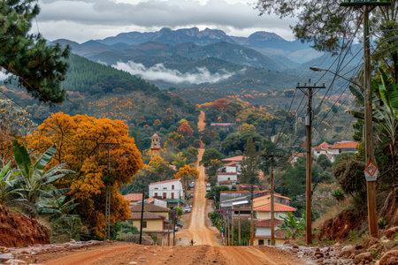Winding Road Through Rural Village With Mountains and Fog in Backgroundの素材