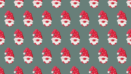 Seamless pattern of cartoon gnome faces with red Santa hats, white beards, and mittens on muted green background. Festive and whimsical design perfect for holiday textiles or wrapping paperの写真素材
