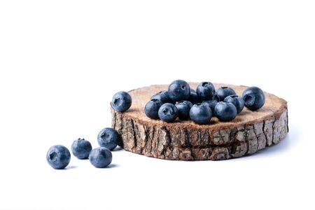 Freshly picked juicy blueberries on a wooden board. Blueberry antioxidant. Healthy eating concept. White background.の写真素材