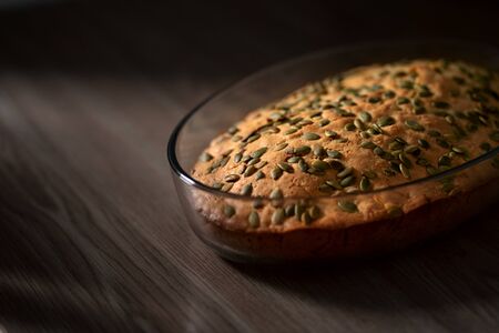 Homemade delicious pumpkin pie sprinkled with pumpkin seeds.