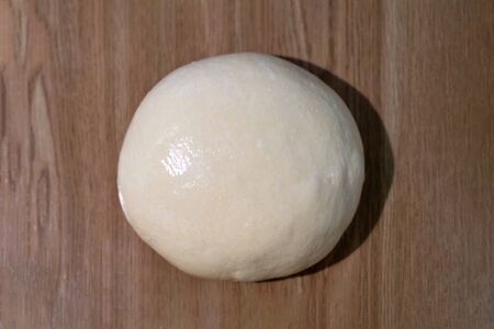 Fresh ball of dough on a wooden table. top view.の写真素材