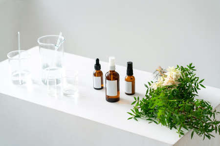 Light cosmetic background. Vials, glass laboratory flasks on the table. Natural cosmetics concept.の写真素材