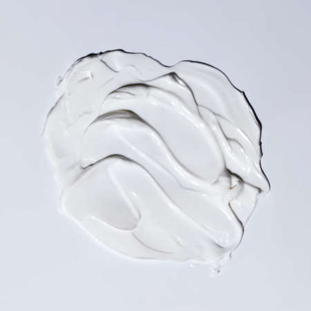 Sample of white cosmetic cream, drops of gel and foam on a gray background.の写真素材