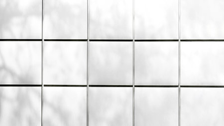 White architectural wall tiles with soft natural shadows in grid layoutの写真素材