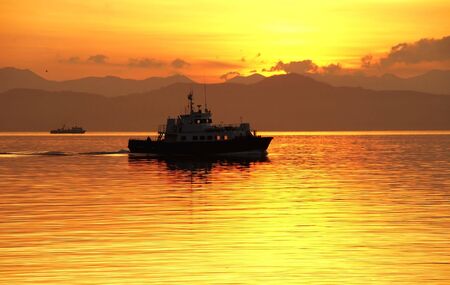 ship returns in port on background of the beautiful sundownの写真素材