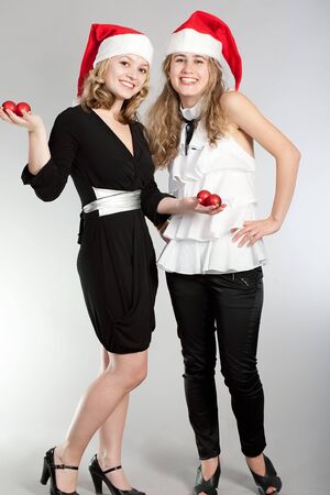 Photographing of two nice girls in caps of Santa Klausの写真素材