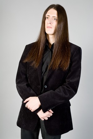 Portrait of the young man with long hair in black clothesの写真素材