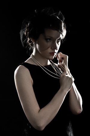 Retro a portrait of the beautiful brunette against a dark backgroundの写真素材