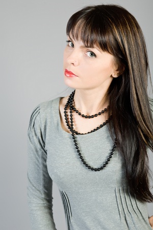 young beautiful girl in a blouse on a grey backgroundの写真素材