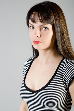 young beautiful girl in a blouse on a grey backgroundの写真素材