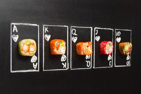 Royal Flush hand drawn Poker cards with sushi roll pieces on dark chalkboard background. Asian rolls...