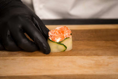 Japanese Gunkan Sake Green with Salmon, cream cheese and rice wrapped in cucumber. Chef preparing...