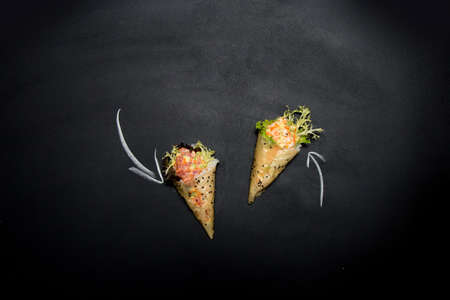 Japanese Sushi Temaki Hand Roll with tiger shrimp and salmon in Mamenori seaweed on chalkboard...