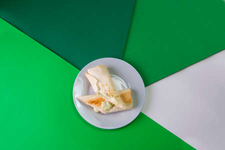 Eastern traditional Grilled rolls of lavash bread (pita) with suluguni cheese and green herbs (dill). picnic lunch food on gray serving plate on colorful background.の写真素材