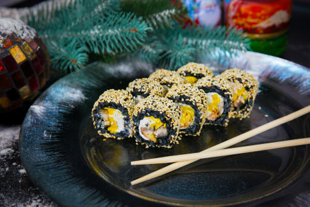 Japanese sushi roll with chopsticks on Christmas decorated plate. Unagi Eel, cream cheese,...