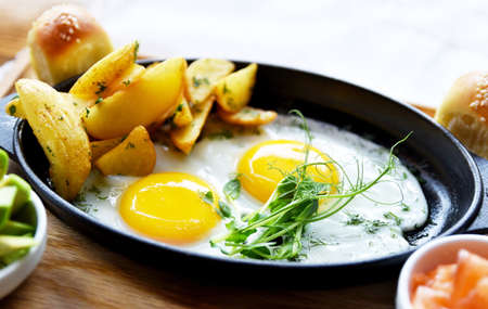 Side view of Traditional European breakfast to Omelette from two eggs, peasant potatoes with green...