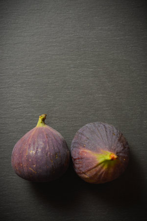 Top view of two fig fruits isolated on slave stone background. Azerbaijani fruit. Copy space image. Selective focusの写真素材